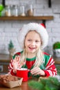 Cute little child girl eating sweet cookies and drinking hot chocolate Royalty Free Stock Photo