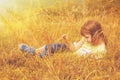 Cute little child girl  lie in a picturesque field with flowers and dry grass against a backdrop of hills and mountains. Happiness Royalty Free Stock Photo
