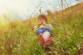 Cute little child girl  lie in a picturesque field with flowers and grass against a backdrop of hills and mountains. Happiness, Royalty Free Stock Photo