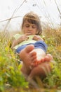 Cute little child girl  lie in a picturesque field with flowers and grass. Happiness,  childhood and  carefree concept. Vertical Royalty Free Stock Photo