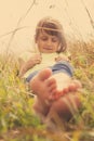 Cute little child girl  lie in a picturesque field with flowers and grass under sunlight on sunny day. Happiness,  childhood and Royalty Free Stock Photo
