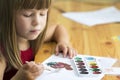 Cute little child girl painting with paintbrush and colorful paints Royalty Free Stock Photo