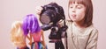 Cute little child girl photographer is shooting portrait of toys dolls  with a DSLR camera. Selective focus on eye Royalty Free Stock Photo