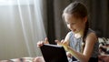 Cute little child girl playing in a tablet computer