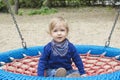 Cute little child having fun on a colorful swing outdoor in the park. Beautiful spring day in children playground Royalty Free Stock Photo