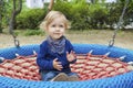 Cute little child having fun on a colorful swing outdoor in the park. Beautiful spring day in children playground Royalty Free Stock Photo