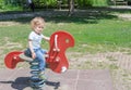 Cute little child having fun playing with colorful wooden toys in the park, beautiful summer sunny day in children playground