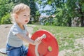 Cute little child having fun playing with colorful wooden toys in the park, beautiful summer sunny day in children playground