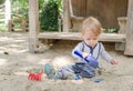 Cute little child having fun playing with sand and colorful toys in the park, beautiful summer sunny day in children playground Royalty Free Stock Photo