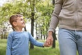 Cute little child holding hands with his father in park Royalty Free Stock Photo