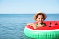 Cute child with inflatable ring in sea on sunny day. Beach holiday Royalty Free Stock Photo