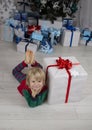 cute little child is lying on floor near large gift box, dreaming of surprise Royalty Free Stock Photo