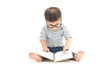 Cute little child play with book and wearing glasses while sitting on floor  over white background Royalty Free Stock Photo