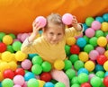 Cute little child playing in ball pit at amusement park Royalty Free Stock Photo