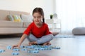 Cute little child playing with puzzles. Space for text