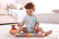 Cute little child playing with xylophone on floor Royalty Free Stock Photo