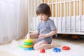 Cute little child plays nesting blocks