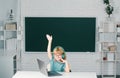 Cute little child with raised hand using laptop computer, kid boy studying through online e-learning. Royalty Free Stock Photo