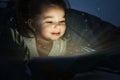 Cute child reading magic book in darkness Royalty Free Stock Photo