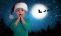 Cute little child and Santa Claus flying in his sleigh against moon sky on background. Christmas celebration Royalty Free Stock Photo