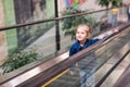 Cute little child in shopping center standing on moving escalator Royalty Free Stock Photo