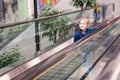 Cute little child in shopping center standing on moving escalator Royalty Free Stock Photo