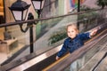 Cute little child in shopping center standing on moving escalator Royalty Free Stock Photo