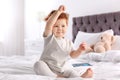 Cute little child sitting on bed Royalty Free Stock Photo