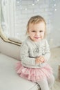 cute little child sitting in chair near Christmas tree. Happy new year. Portrait little girl. Christmas concept Royalty Free Stock Photo