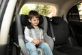 Cute little child sitting in safety seat inside car Royalty Free Stock Photo