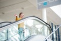 Cute little child standing on moving staircase