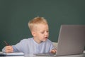 Cute little child using laptop computer, kid boy studying through online e-learning. Little funny system administrator Royalty Free Stock Photo