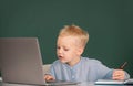 Cute little child using laptop computer, kid boy studying through online e-learning. Little funny system administrator Royalty Free Stock Photo
