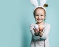 Cute little child wearing bunny ears on Easter day. Girl holding painted eggs celebrating Royalty Free Stock Photo