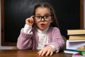 Cute little child wearing glasses at desk. First time at school