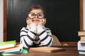 Cute little child wearing glasses at desk. First time at school Royalty Free Stock Photo