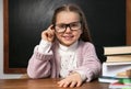 Cute child wearing glasses at desk in classroom. First time at school Royalty Free Stock Photo