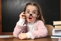 Cute little child wearing glasses at desk in classroom Royalty Free Stock Photo
