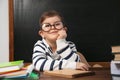 Cute little child wearing glasses at desk. First time at school Royalty Free Stock Photo