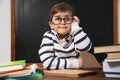 Cute little child wearing glasses in classroom. First time at school Royalty Free Stock Photo