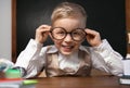 Cute little child wearing glasses at desk. First time at school Royalty Free Stock Photo