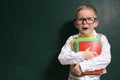 Cute little child wearing glasses near chalkboard. First time at school Royalty Free Stock Photo