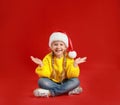 Cute little child wearing Santa hat on red. Christmas holiday Royalty Free Stock Photo