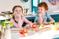 cute little children in aprons cooking vegetable salad together Royalty Free Stock Photo