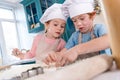 cute little children in chef hats and aprons preparing cookies Royalty Free Stock Photo