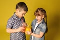 Cute little children with citrus juice on color background