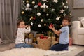 Cute little children decorating Christmas tree at home Royalty Free Stock Photo