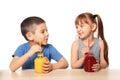 Cute little children drinking citrus juice at table on white background