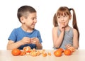 Cute little children eating citrus fruit at table on white background