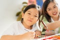 cute little children happy, smile, look at camera while painting color on paper art in education classroom. asian beautiful Royalty Free Stock Photo
